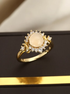 Nahaufnahme eines Vintage-Goldrings mit rosa ovalem Cabochon und Zirkonia-Heiligenschein