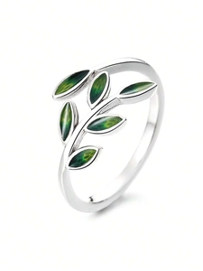 Macro detail of silver adjustable ring featuring green enamel leaves in forest leaf design