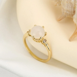 Goldener Kronenring mit ovalem weißem Edelstein und Diamanten auf Seide
