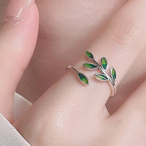 Minimalist silver open ring featuring delicate green leaf design for a fresh forest style