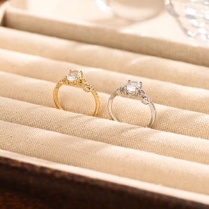 Macro-opname van goud- en zilverkleurige ringen met rankvorm en moissanite stenen