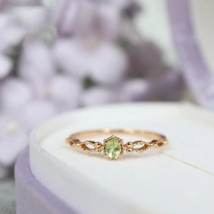 Macro di anello in oro rosa con peridoto verde ovale e dettagli in zircone traforato