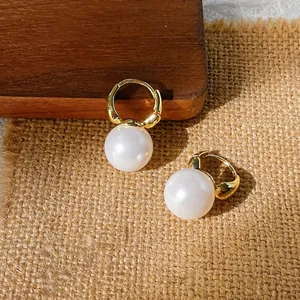Close-up of gold-plated S925 silver hoop earrings with round faux pearls and metal hallmarks