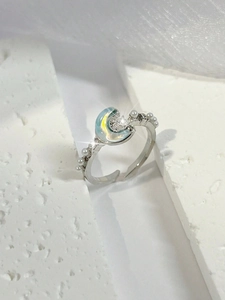 Detalle macro de anillo de luna con piedra azul iridiscente y perlas delicadas