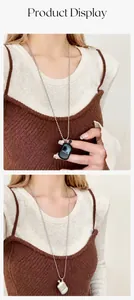Close-up of minimalist perfume bottle pendant necklace in black and silver finishes