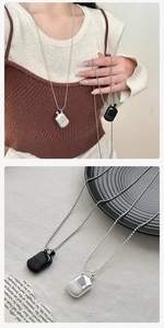Detail of vintage silver and black perfume bottle pendants on a beaded chain necklace