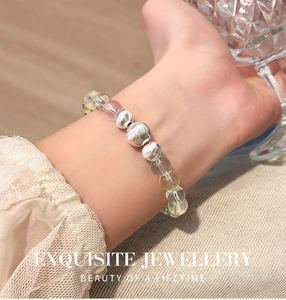 Detailed shot of a colorful crystal beaded bracelet with engraved silver metal spacers