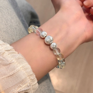 Colorful crystal beaded bracelet with silver textured metal spheres on a female wrist