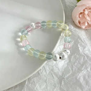 Colorful crystal beaded bracelet with pink and blue stones on white ceramic plate