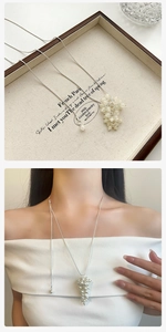 Detail van een zilveren slangenketting met druiventros hanger bij een model