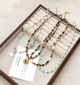 Detail van boho kralenkettingen met natuursteen, parels en metalen bedeltjes
