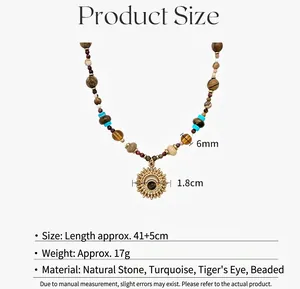 Detail van turquoise en tijgeroog kralenketting met een gouden zonnehanger