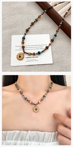 Detail van de boho kralenketting met turquoise stenen en goudkleurige zonnehanger-stijl