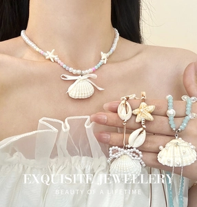 Détail du collier thème marin avec pendentifs en coquillage, perles et perles bleues