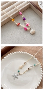 Détails de perles colorées, d'étoiles de mer et de coquillages sur colliers de plage
