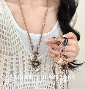 Détail du collier à pendentif fleur rétro avec perle et plaque métallique 'Believe'