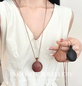 Detailed close-up of three wood gourd pendants in mahogany, dark brown, and black ebony finishes