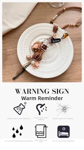 Détail du pendentif fleur en tissu avec perles et breloque Believe sur une assiette blanche