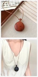 Detail view of handmade sandalwood gourd pendant necklace in red and black wood finishes