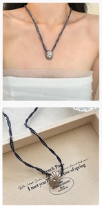 Nahaufnahme des Vintage-Anhängers mit Faltenmuster an einer blauen Kordelkette