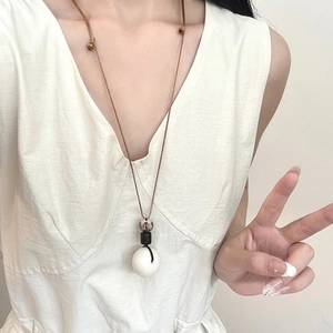 Sautoir minimaliste en graines de Bodhi avec pendentif géométrique sur mannequin