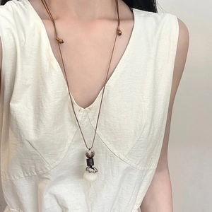 Long collier Bodhi style Zen avec pendentif en jade sur tenue naturelle en lin