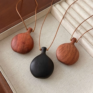 Vintage sandalwood pendant necklace with teardrop shape on natural linen jewelry box