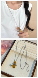 Detail van de zilveren titanium lange ketting met gele natuursteen en druppelhanger