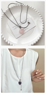 Détail de pendentifs cœur en pierre rose et violette sur une élégante chaîne en argent