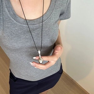 Silver spoon pendant necklace with black cord on model, minimalist adjustable jewelry