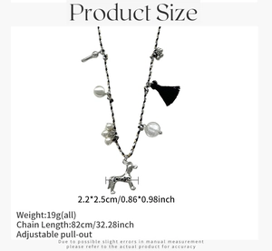 Détail du collier avec pendentif chiot argenté, perles, pompon noir et breloques en forme d'os