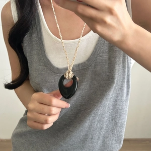 Collana minimalista con ciondolo ovale nero e cordino intrecciato bianco