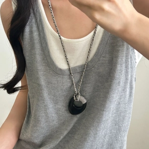 Collana con ciondolo rotondo irregolare con cordino intrecciato e dettagli in argento