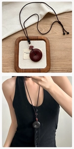 Détail de pendentifs vintage en bois de santal rouge et noir sur cordes tressées