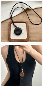 Gros plan détaillé du collier pendentif Ping'an Kou en bois de rose avec cordon réglable