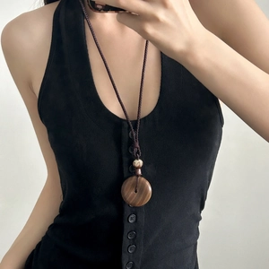 Collier pendentif vintage en bois de santal avec corde tressée marron sur un modèle