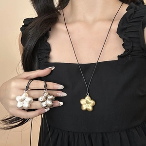 Collier avec pendentif fleur minimaliste et finitions en métal mat et poli