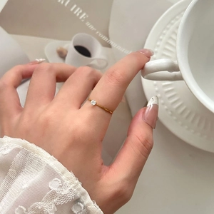 Elegante anillo de acero de titanio chapado en oro de 18K con circonita fina en el dedo