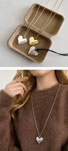 Detailweergave van hartvormige hangers in goud en zilver met diverse koordkettingen