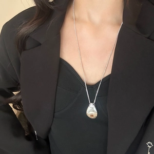 Elegante collana d'argento con ciondolo a goccia e ambra indossata da una modella