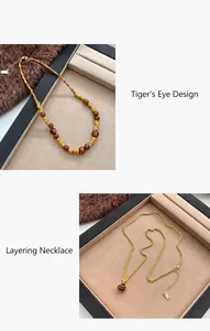 Detail van gelaagde tijgeroog kettingen met goudkleurige metalen ringen en kralen