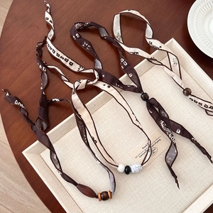 Bohemian zijden lint ketting met houten kralen en marmeren stenen in een dienblad