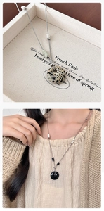 Detail van Dalmatische jaspis donut hanger met kralenketting op een vintage dienblad