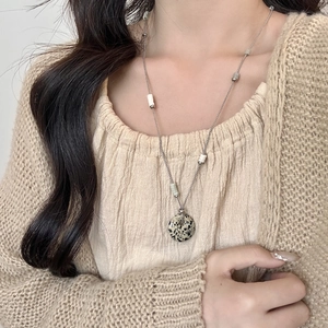 Dalmatiër jaspis donut hanger ketting met zilveren ketting op model in beige trui