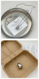 Macro detail of silver teardrop pendant with mirror polished finish and lobster clasp