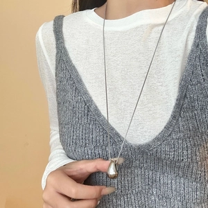 Polished teardrop pendant necklace in stainless steel on a layered autumn outfit