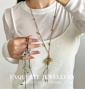 Detailed macro view of minimalist puppy pendant necklace with delicate tassel and beads