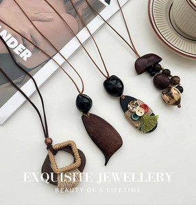 Detail van retro boho lange kettingen met houten kralen en gekleurde kwastjes