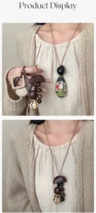 Detail van handgemaakte vintage notendop hangers met rustieke houten kralen en zijden kwastjes
