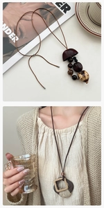 Macro detail van de lange vintage boho ketting met houten kralen en natuurlijke hanger